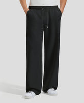 Men's black baggy sweatpants, front view. Wide leg sweatpants men, showing fit and drape.
