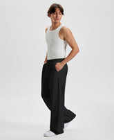 Men's black wide leg sweatpants, side view. Baggy pants men with roomy fit.