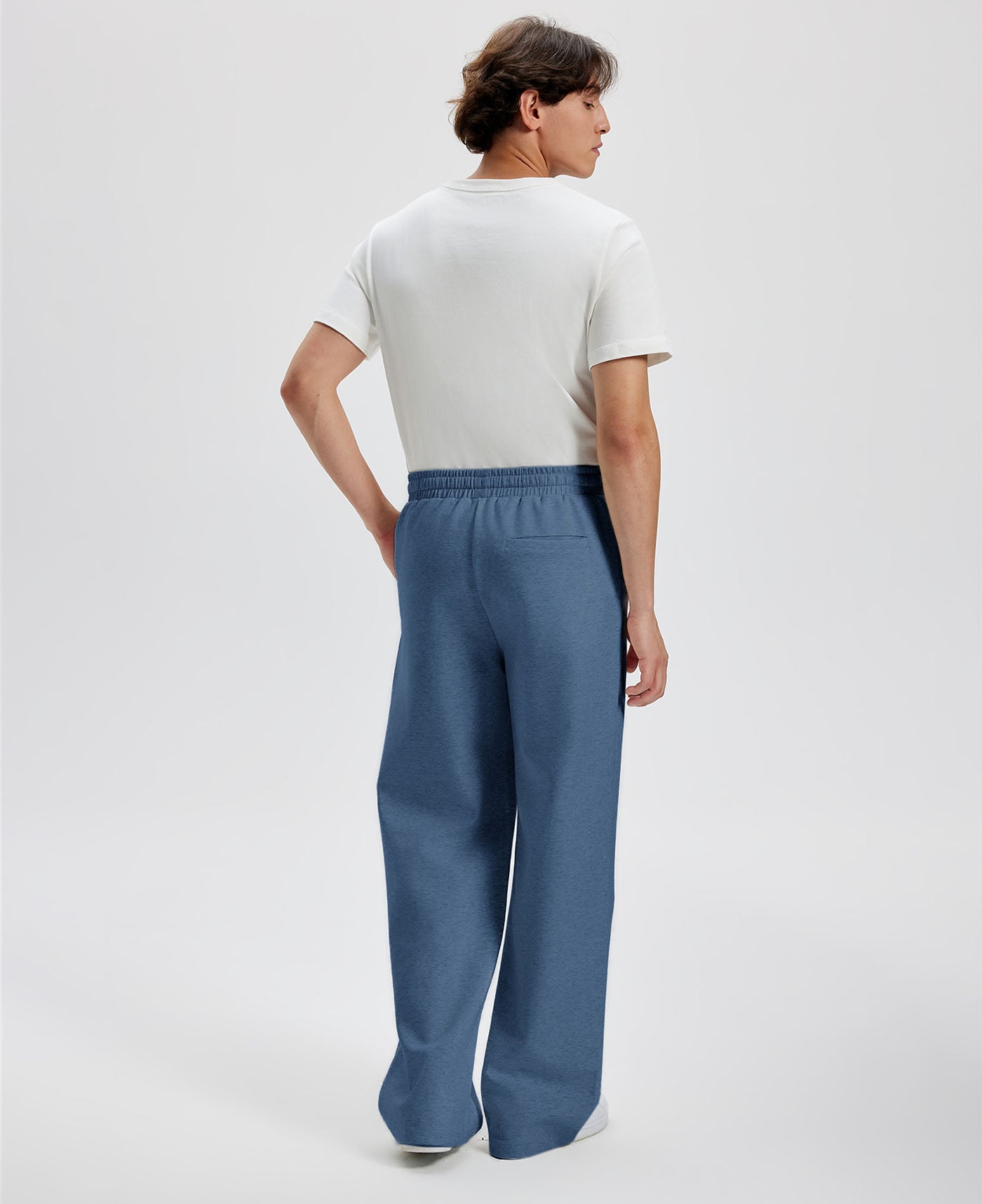 Cotton blue sweatpants for men, back view. Elastic waistband and back pocket.