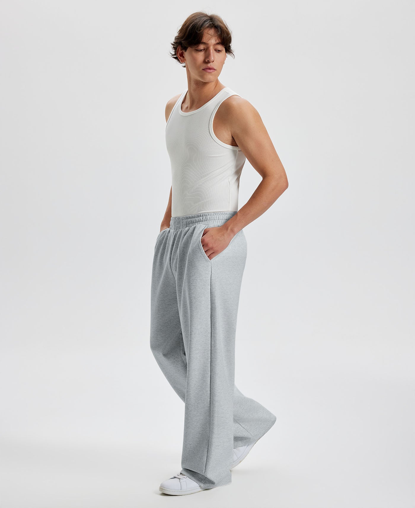 Men's light grey wide leg sweatpants, side view. Baggy pants men with roomy fit.