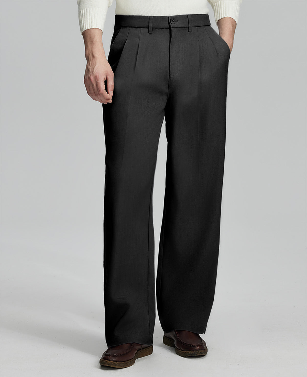 Man in white knit, black wide-leg dress pants and brown shoes¡ªhand in pocket showing pleated front and fluid drape.