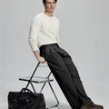 Styled with white sweater and black bag, leaning on chair¡ªelegant yet relaxed look in men¡¯s black baggy pleated dress pants.