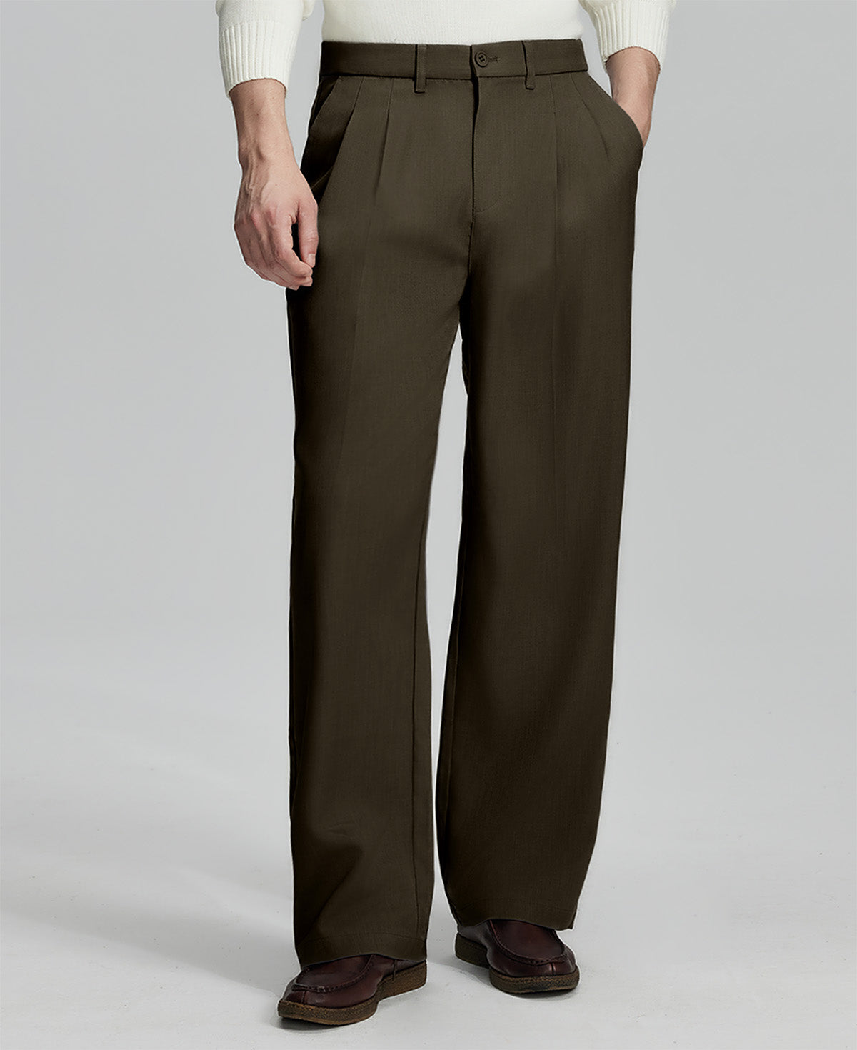 Man in white knit, coffee wide-leg dress pants and brown shoes¡ªhand in pocket showing pleated front and fluid drape.