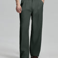 Man in white knit, dark grey wide-leg dress pants and brown shoes¡ªhand in pocket showing pleated front and fluid drape.