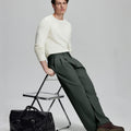 Styled with white sweater and black bag, leaning on chair¡ªelegant yet relaxed look in men¡¯s dark grey baggy pleated dress pants.
