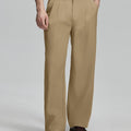 Man in white knit, khaki wide-leg dress pants and brown shoes¡ªhand in pocket showing pleated front and fluid drape.