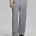 Man in white knit, light grey wide-leg dress pants and brown shoes¡ªhand in pocket showing pleated front and fluid drape.