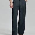 Man in white knit, navy wide-leg dress pants and brown shoes¡ªhand in pocket showing pleated front and fluid drape.