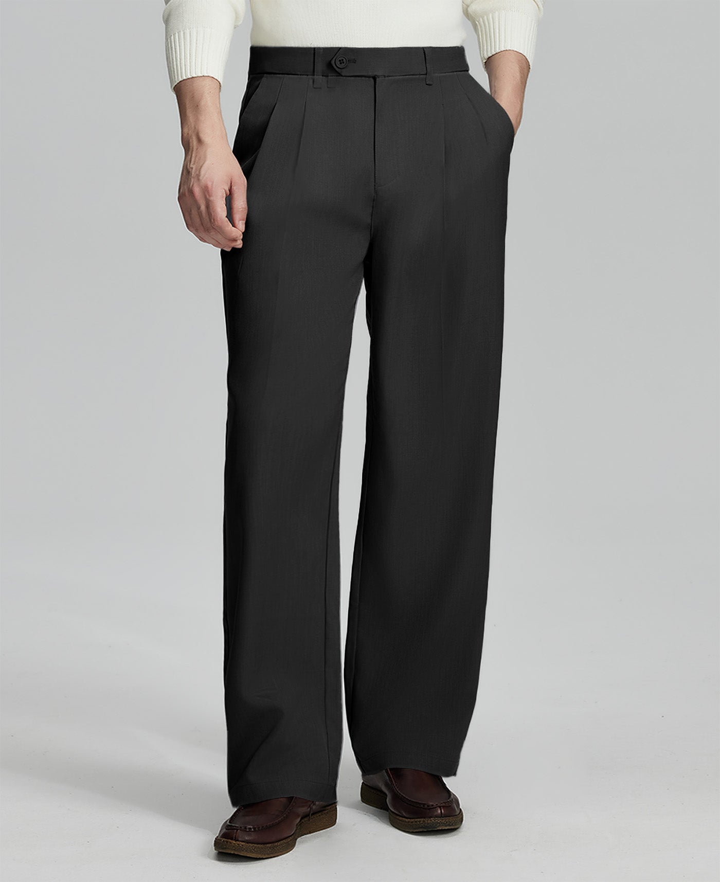 Man in white sweater, black pleated pants & brown shoes, showcasing the wide-leg cut and drape of Baggy Pleated Dress Pants for Men.