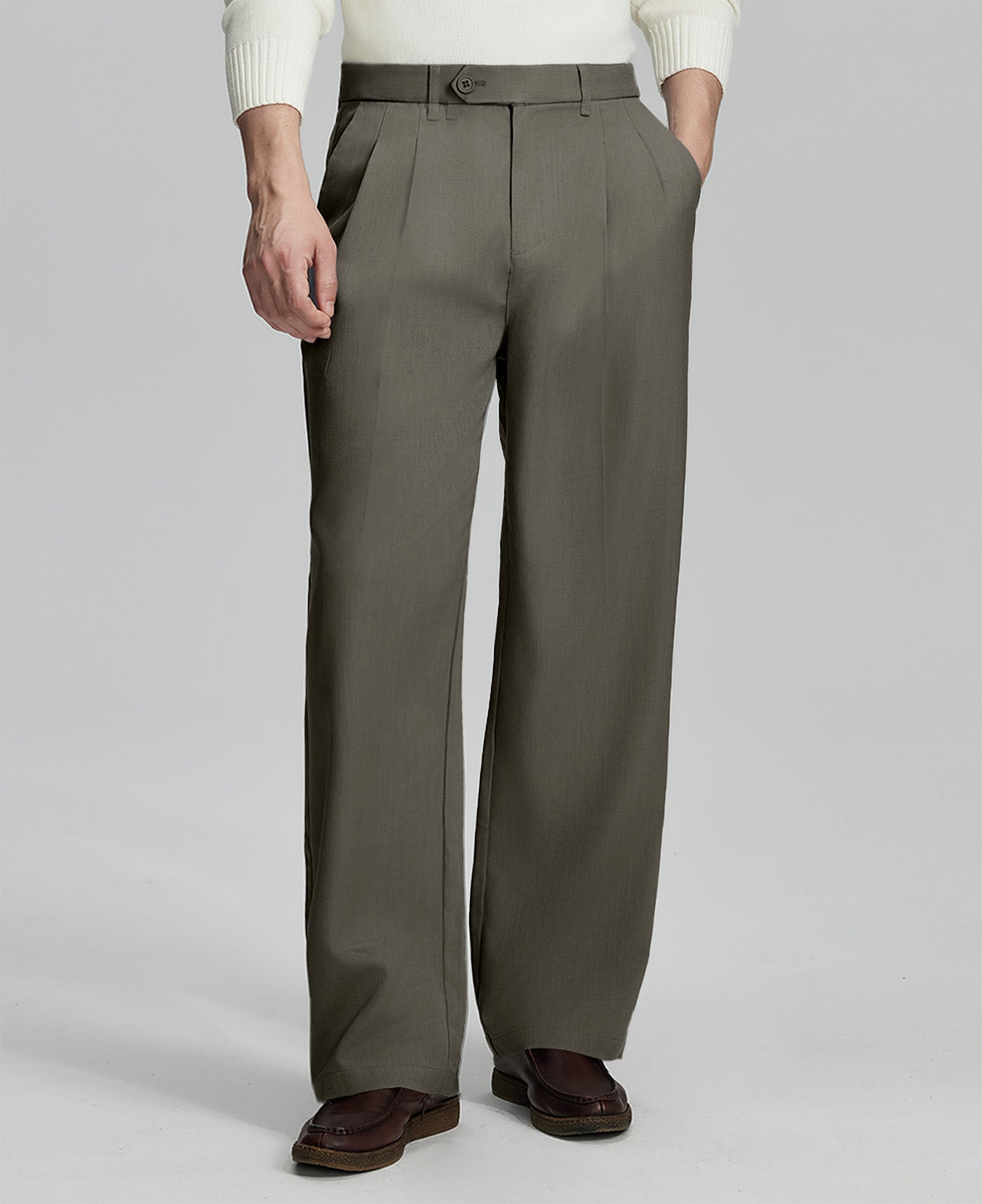 Man in white sweater, brown pleated pants & brown shoes, showcasing the wide-leg cut and drape of Baggy Pleated Dress Pants for Men.