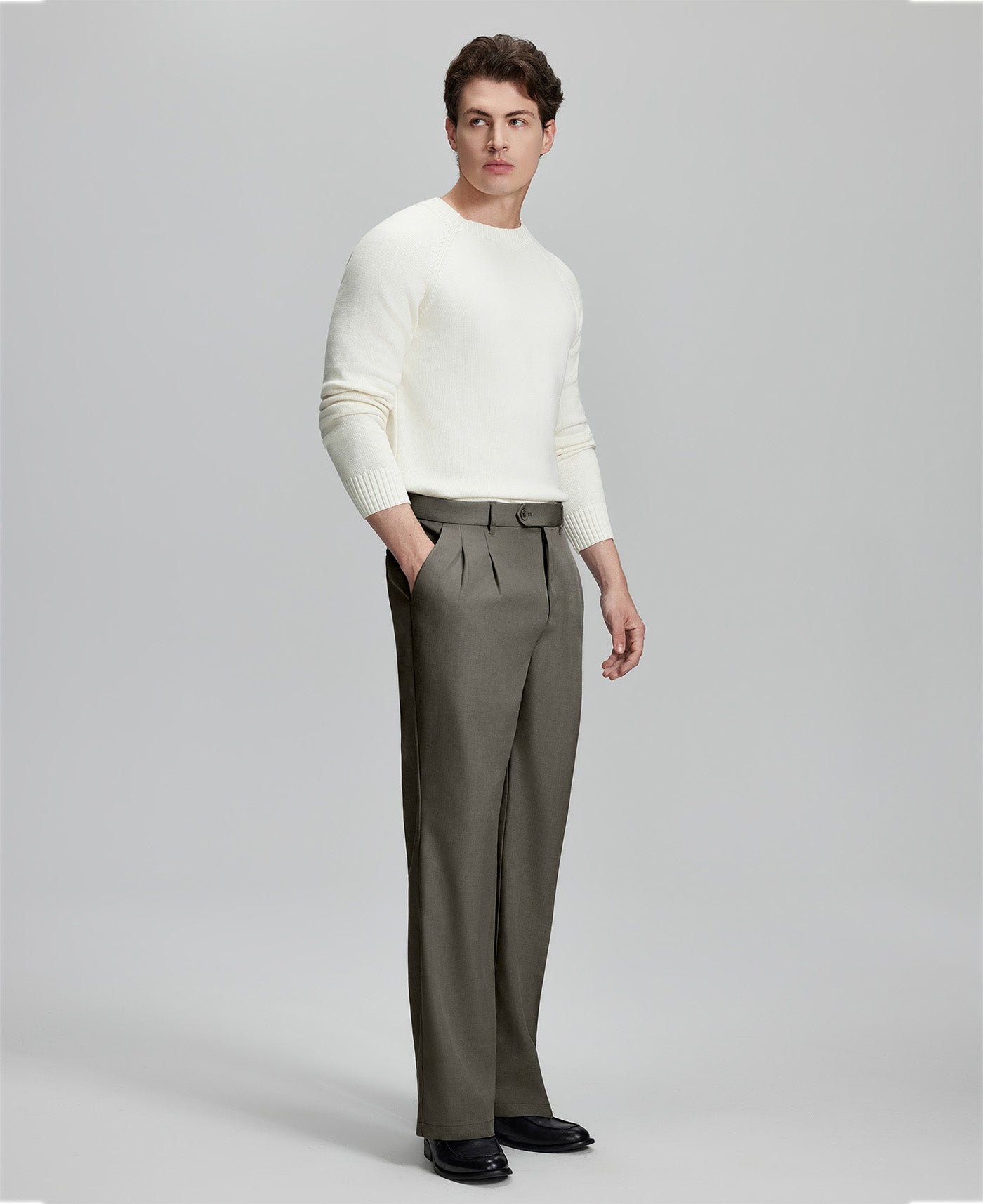 Side view of model with hand in pocket, highlighting the pleats and line of the Brown Baggy Pleated Dress Pants for Men.