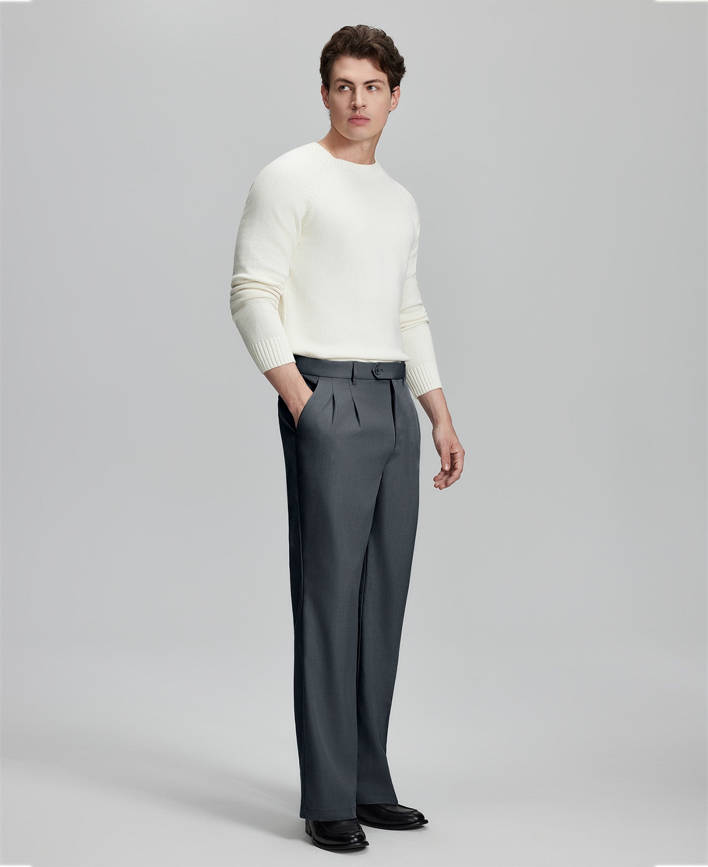Side view of model with hand in pocket, highlighting the pleats and line of the Dark Grey Baggy Pleated Dress Pants for Men.