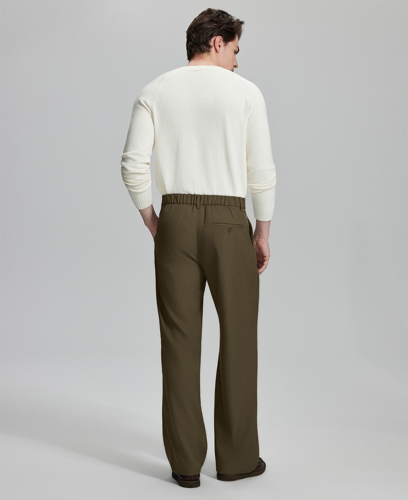 Side view of model with hand in pocket, highlighting the pleats and line of the Light Brown Baggy Pleated Dress Pants for Men.