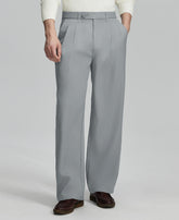 Man in white sweater, light grey pleated pants & brown shoes, showcasing the wide-leg cut and drape of Baggy Pleated Dress Pants for Men.
