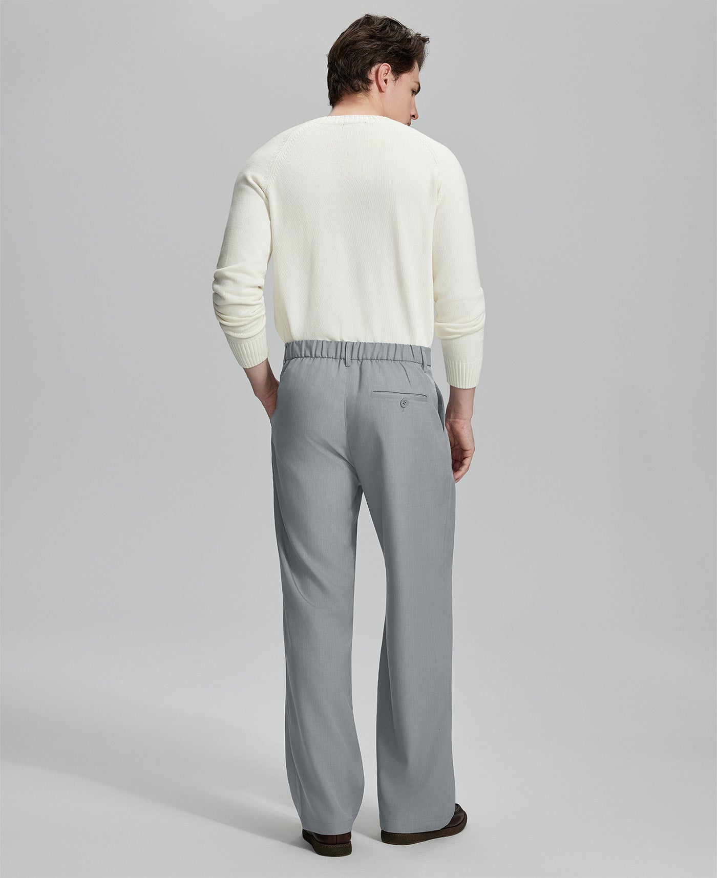 Back view of men's light grey dress pants showing elastic waistband and back pockets, emphasizing the silhouette of Extended Tab & Inner Drawstring design.