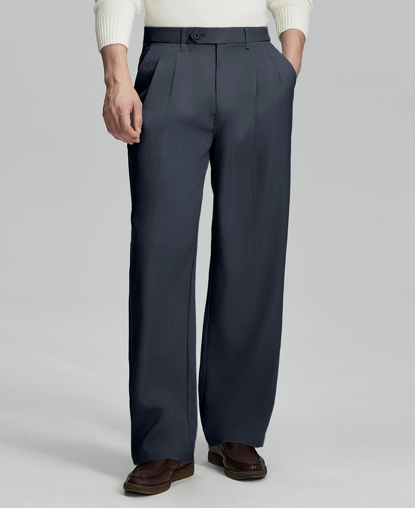 Man in white sweater, navy blue pleated pants & brown shoes, showcasing the wide-leg cut and drape of Baggy Pleated Dress Pants for Men.