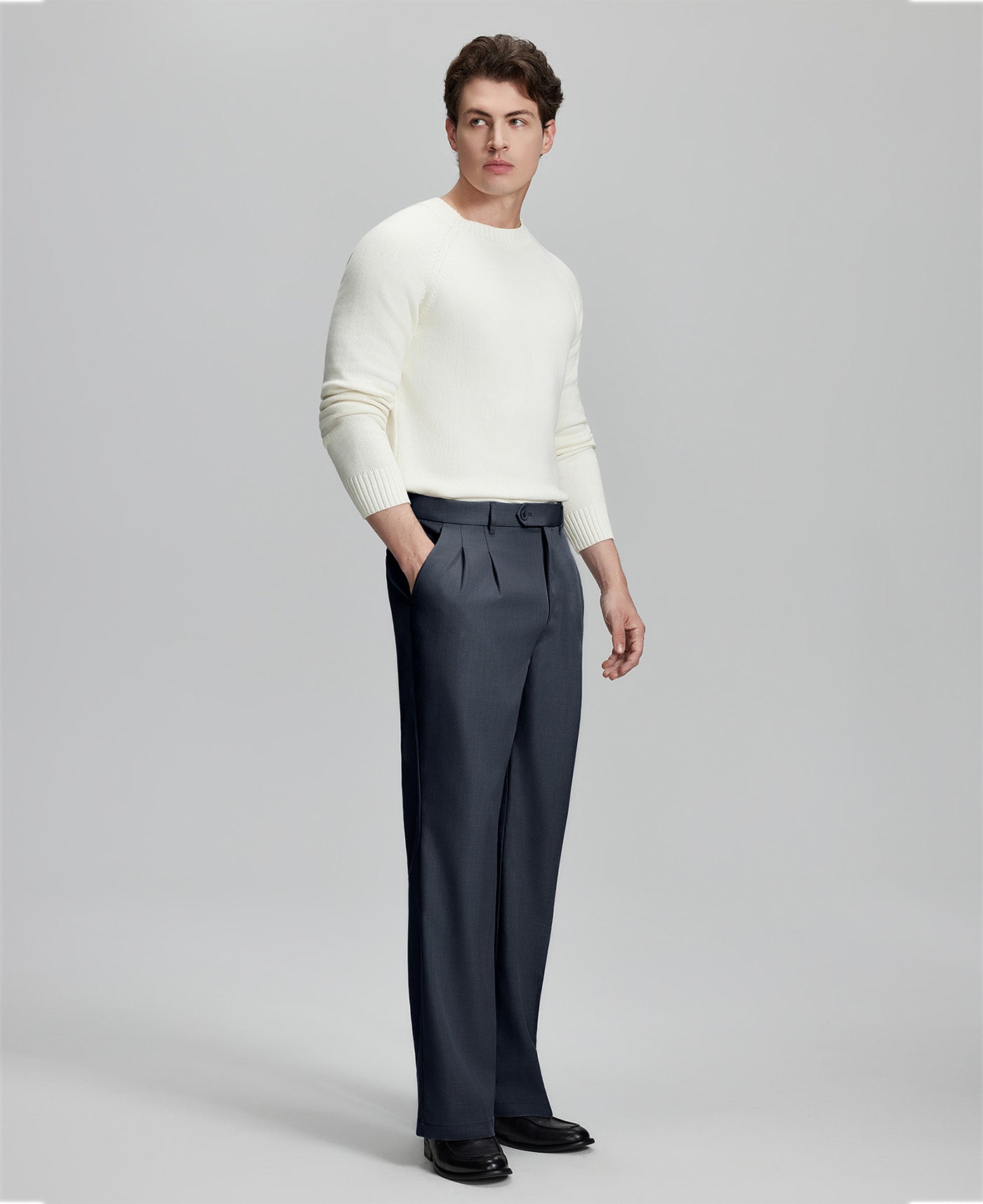 Side view of model with hand in pocket, highlighting the pleats and line of the Navy Blue Baggy Pleated Dress Pants for Men.