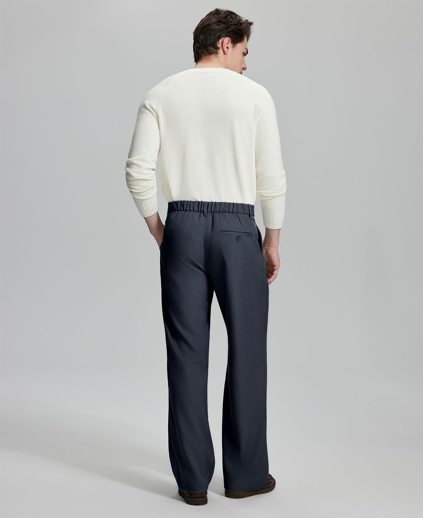 Back view of men's navy blue dress pants showing elastic waistband and back pockets, emphasizing the silhouette of Extended Tab & Inner Drawstring design.