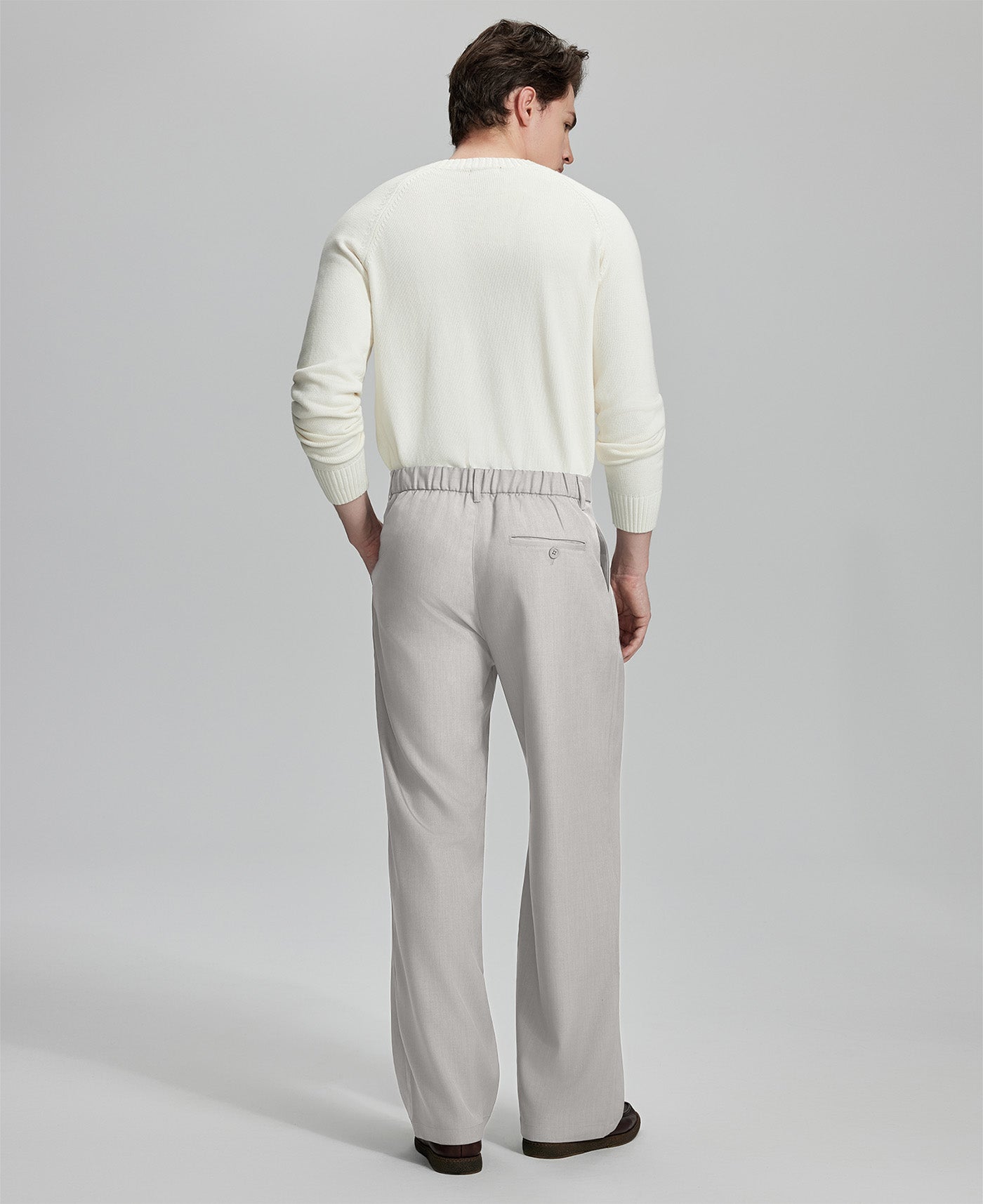 Back view of men's dress pants showing elastic waistband and back pockets, emphasizing the silhouette of Extended Tab & Inner Drawstring design.