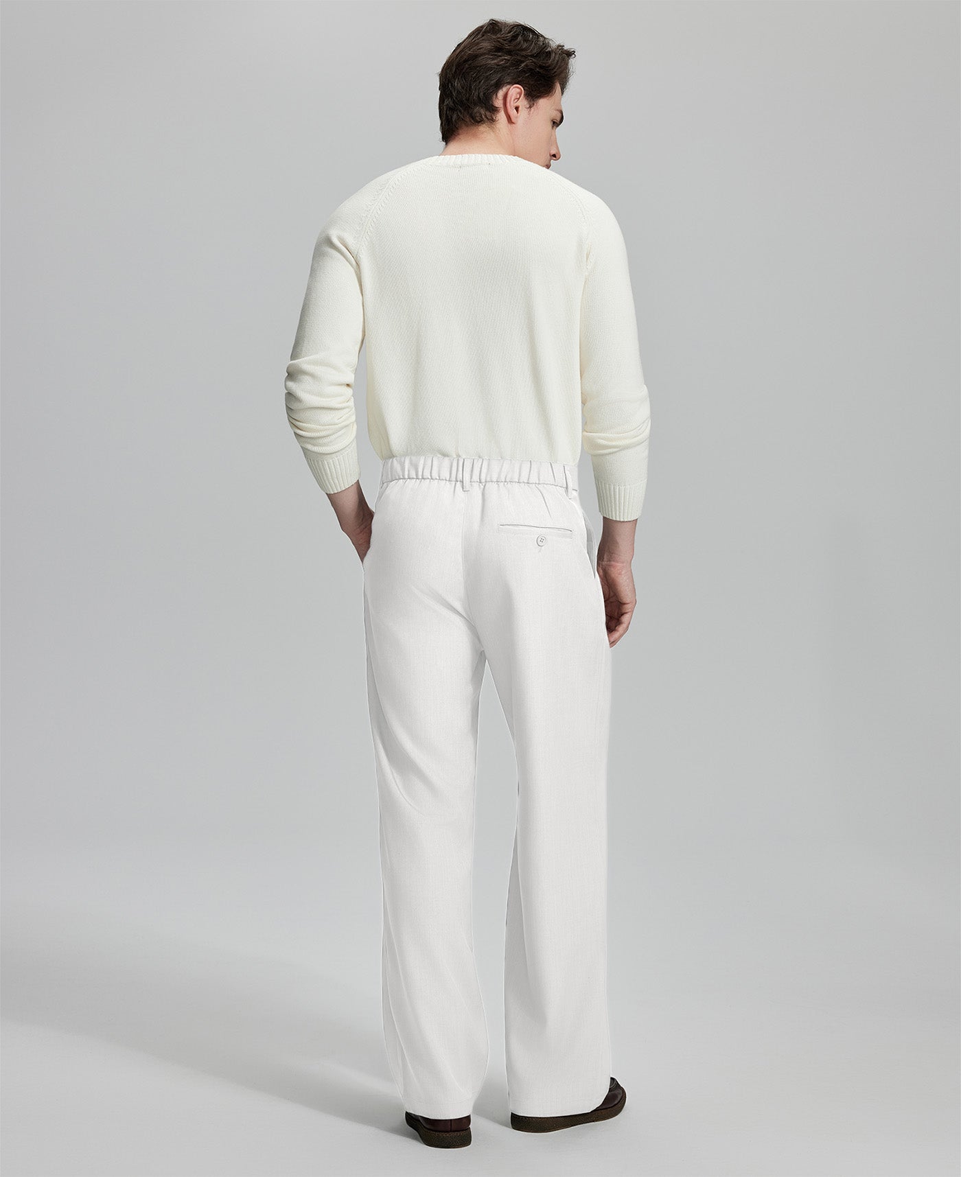 Back view of men's white dress pants showing elastic waistband and back pockets, emphasizing the silhouette of Extended Tab & Inner Drawstring design.