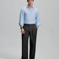 Model in light blue shirt and black trousers, presenting a complete outfit for a professional look.