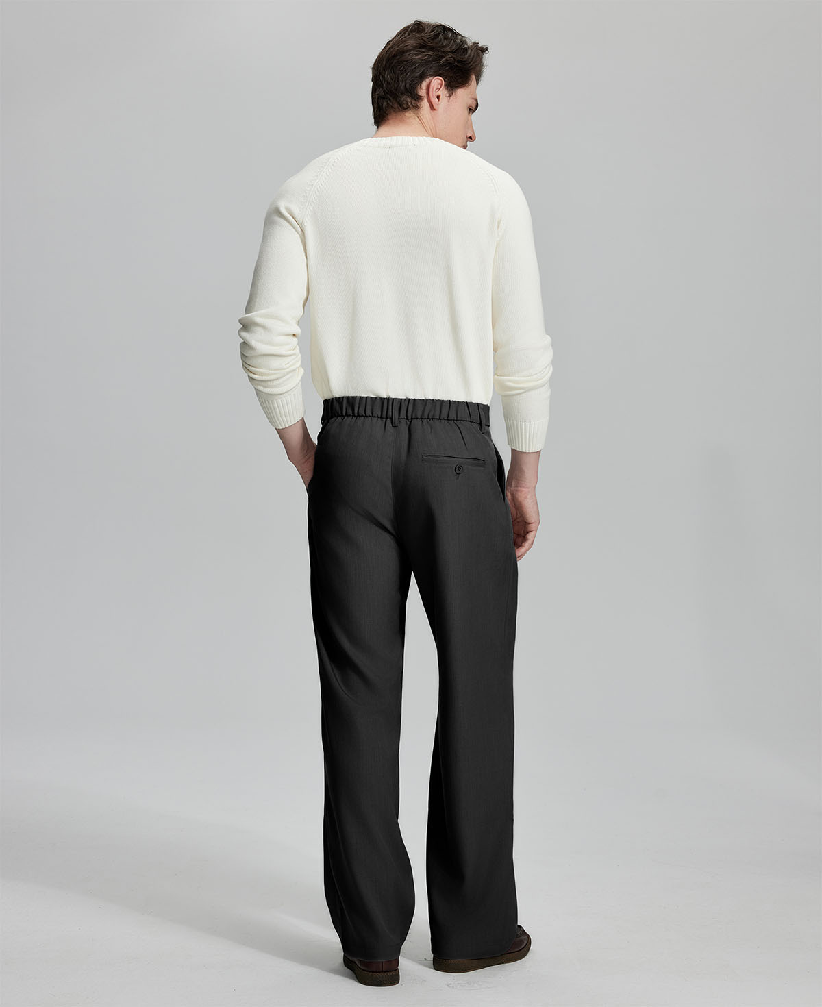 Back view showing elastic waistband and rear pockets on men's vintage-style black dress pants for enhanced comfort.