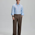 Model in light blue shirt and coffee trousers, presenting a complete outfit for a professional look.