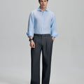 Model in light blue shirt and dark gray trousers, presenting a complete outfit for a professional look.