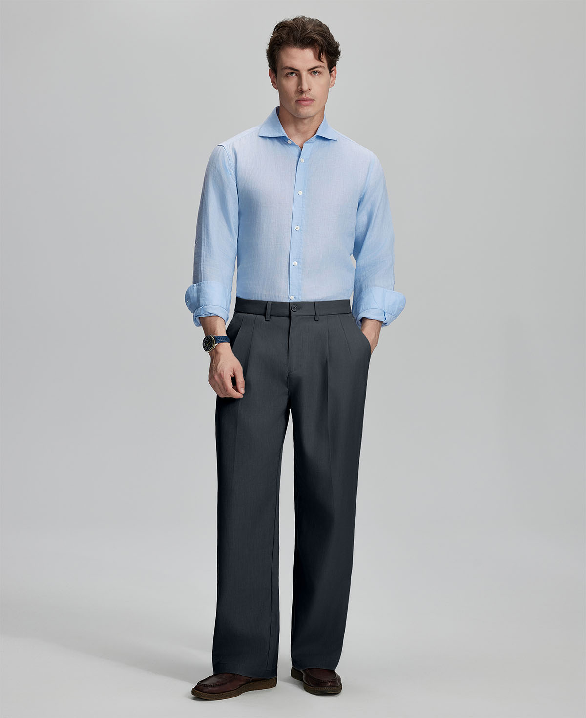 Model in light blue shirt and dark gray trousers, presenting a complete outfit for a professional look.