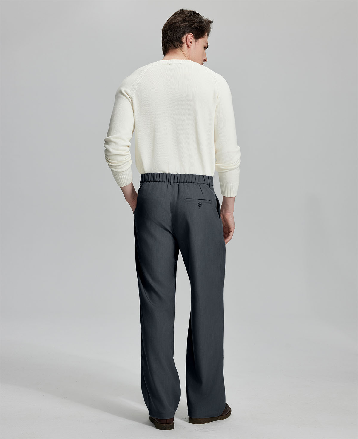 Back view showing elastic waistband and rear pockets on men's vintage-style dark gray dress pants for enhanced comfort.