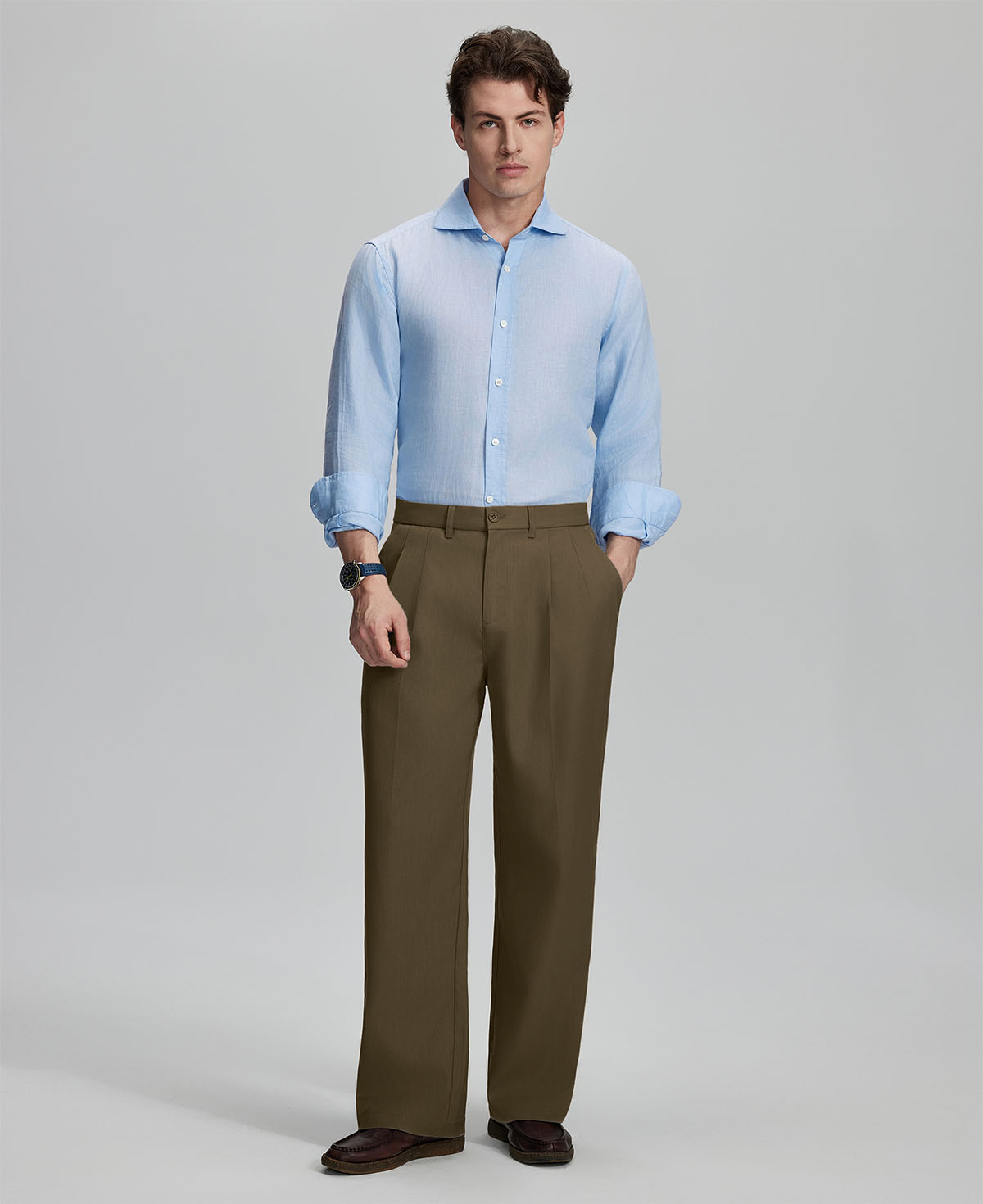 Model in light blue shirt and light brown trousers, presenting a complete outfit for a professional look.
