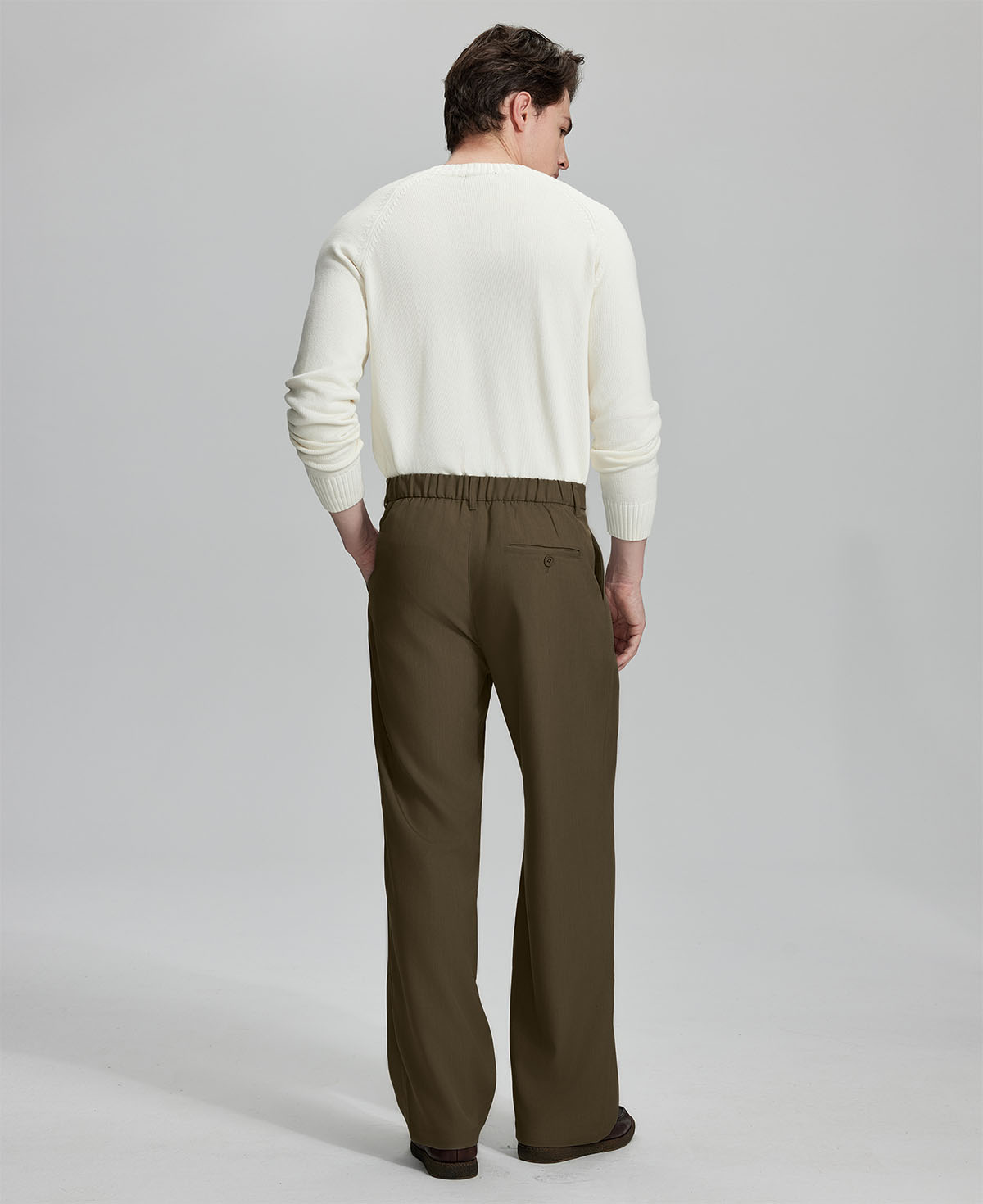 Back view showing elastic waistband and rear pockets on men's vintage-style light brown dress pants for enhanced comfort.