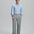Model in light blue shirt and light grey trousers, presenting a complete outfit for a professional look.