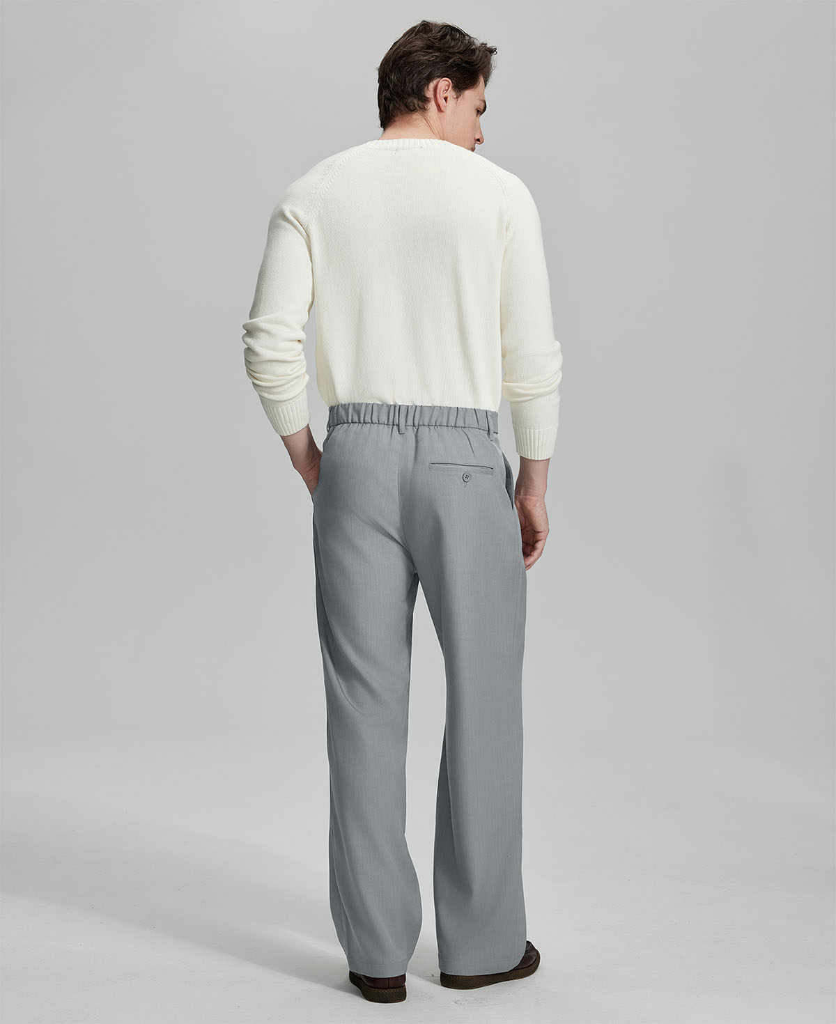 Back view showing elastic waistband and rear pockets on men's vintage-style light grey dress pants for enhanced comfort.