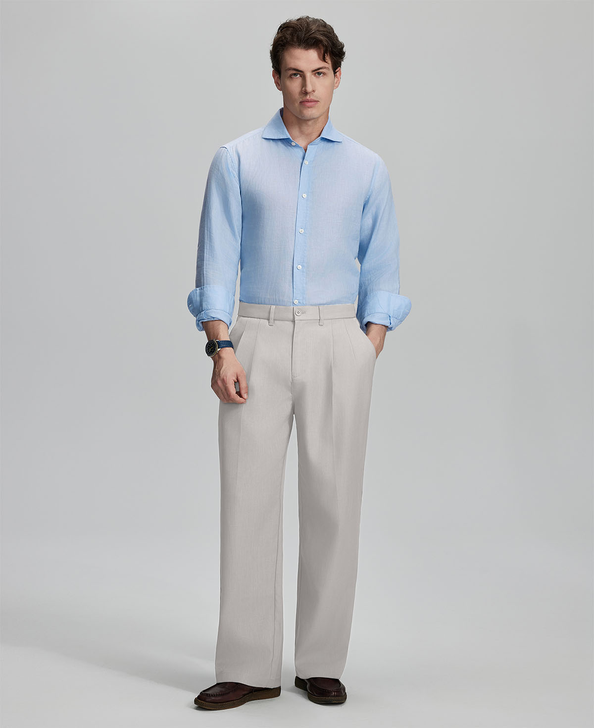 Model in light blue shirt and stone grey trousers, presenting a complete outfit for a professional look.