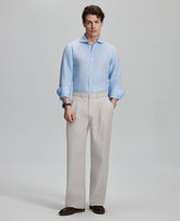 Model in light blue shirt and stone grey trousers, presenting a complete outfit for a professional look.