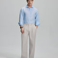 Model in light blue shirt and stone grey trousers, presenting a complete outfit for a professional look.