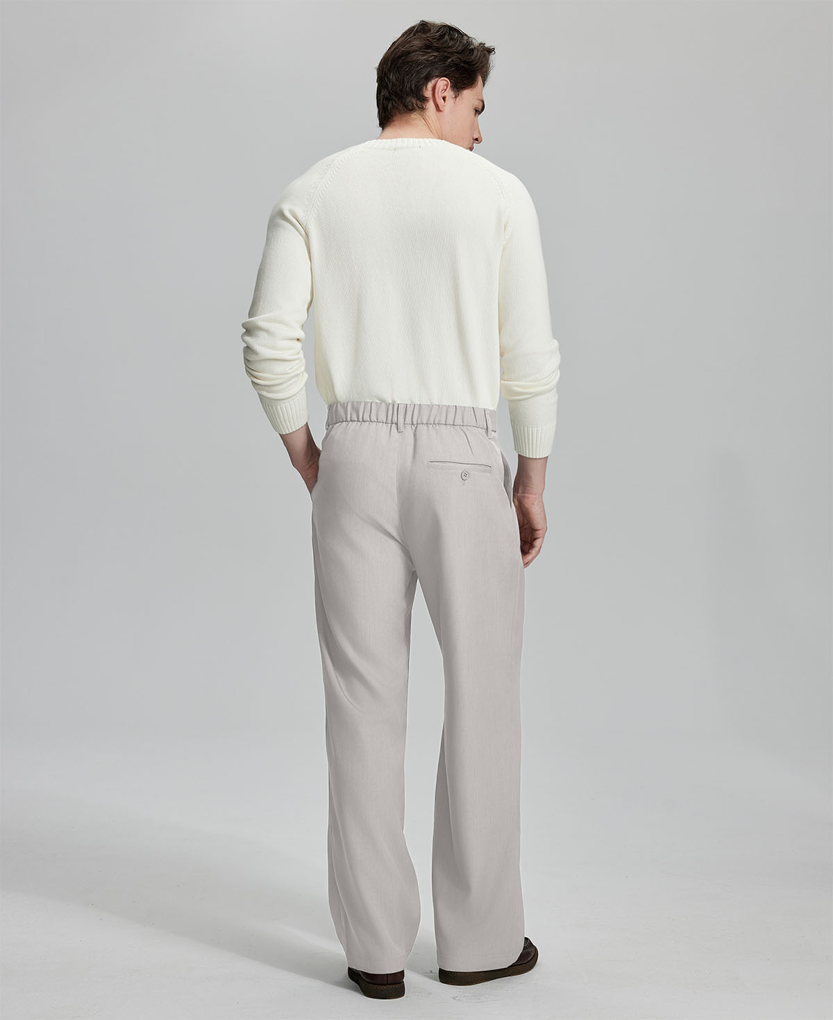 Back view showing elastic waistband and rear pockets on men's vintage-style stone grey dress pants for enhanced comfort.