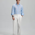 Model in light blue shirt and white trousers, presenting a complete outfit for a professional look.