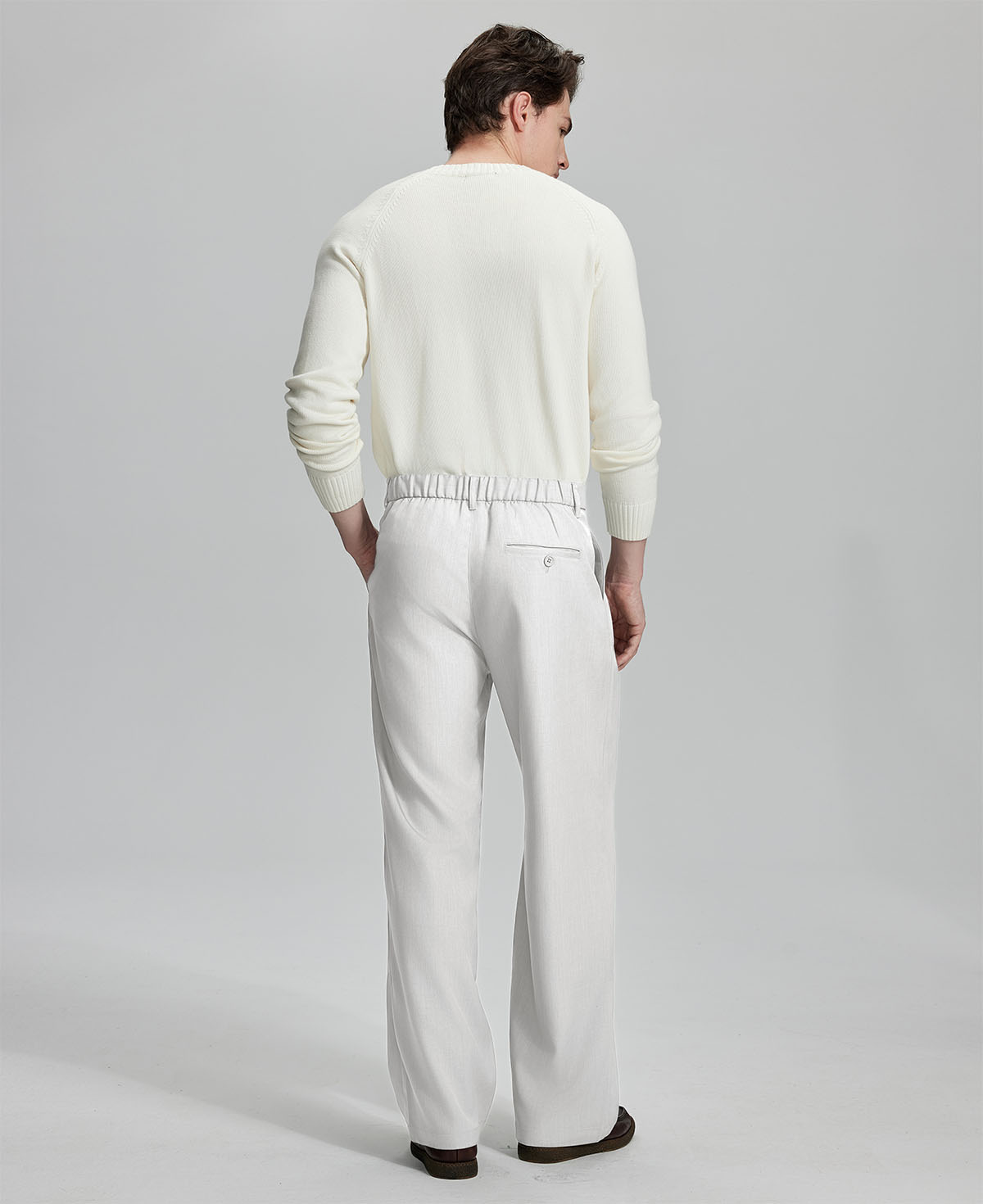 Back view showing elastic waistband and rear pockets on men's vintage-style white dress pants for enhanced comfort.