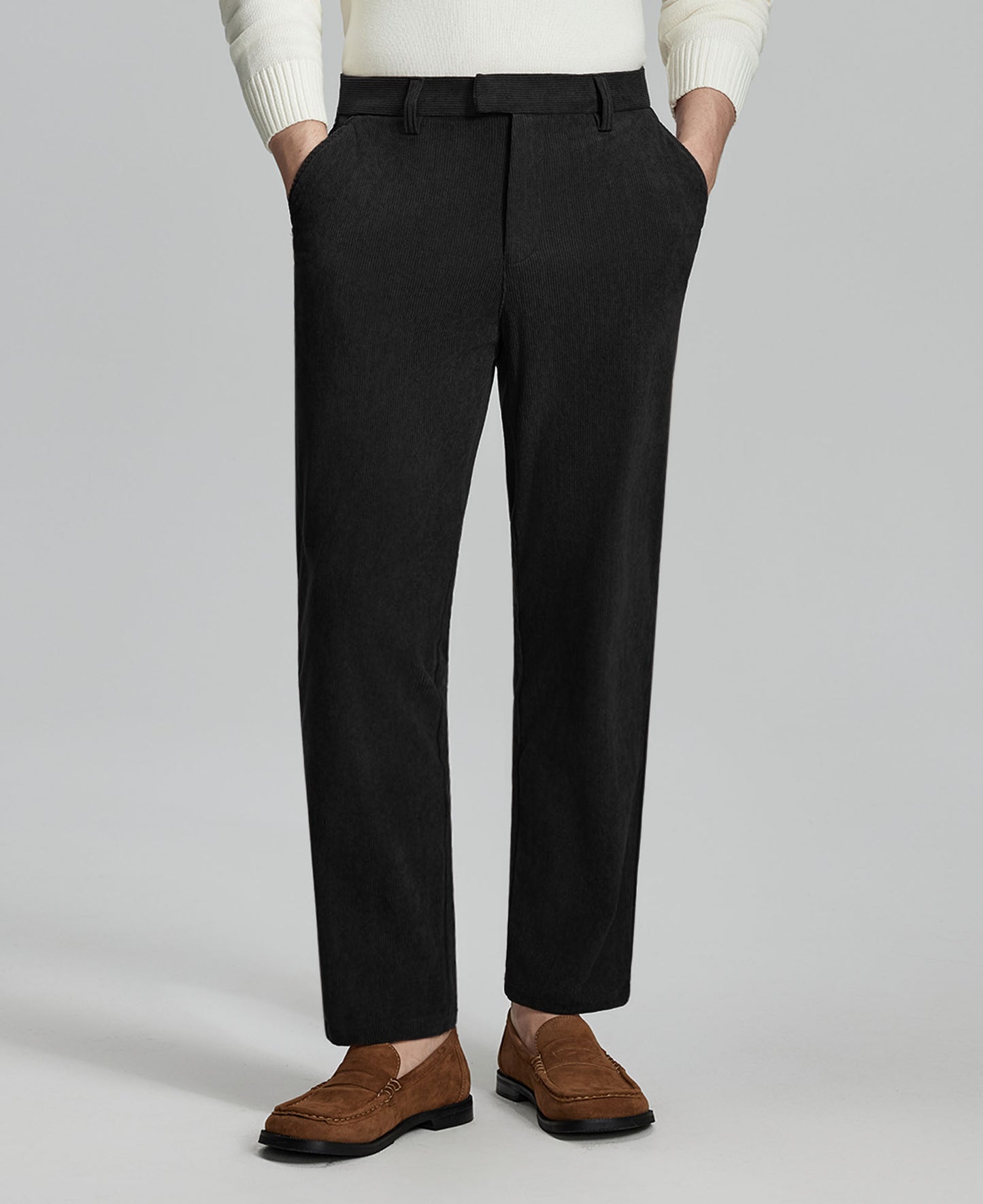 Man in white sweater, black Men's Corduroy Dress Pants, and brown loafers showing fabric texture and drape.