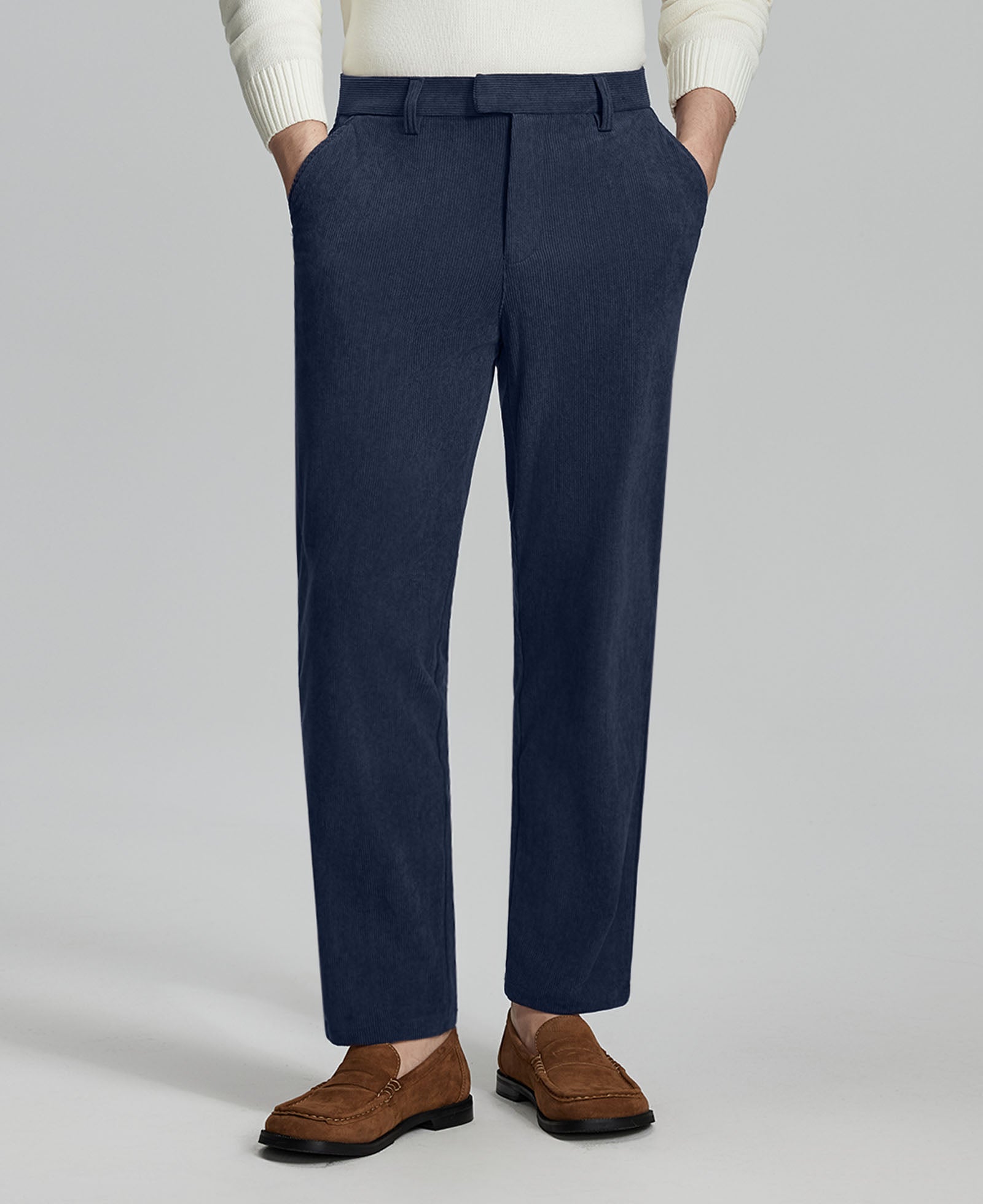 Man in white sweater, navy Men's Corduroy Dress Pants, and brown loafers showing fabric texture and drape.