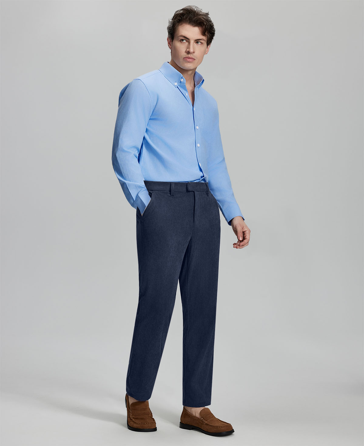 Model in light blue shirt and navy Men's Corduroy Dress Pants, showcasing smart business casual style.
