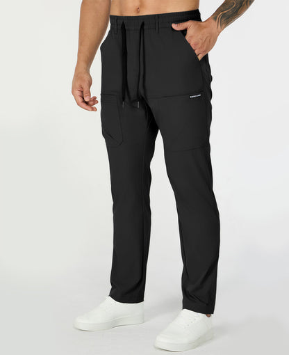 Man in black multipants with drawstring waist and multiple pockets, white sneakers, hand in pocket showing side logo.