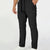 Man in black multipants with drawstring waist and multiple pockets, white sneakers, hand in pocket showing side logo.