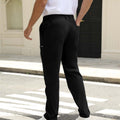 Back view of pants showing rear pocket design and overall silhouette, man with hand in back pocket for storage detail.