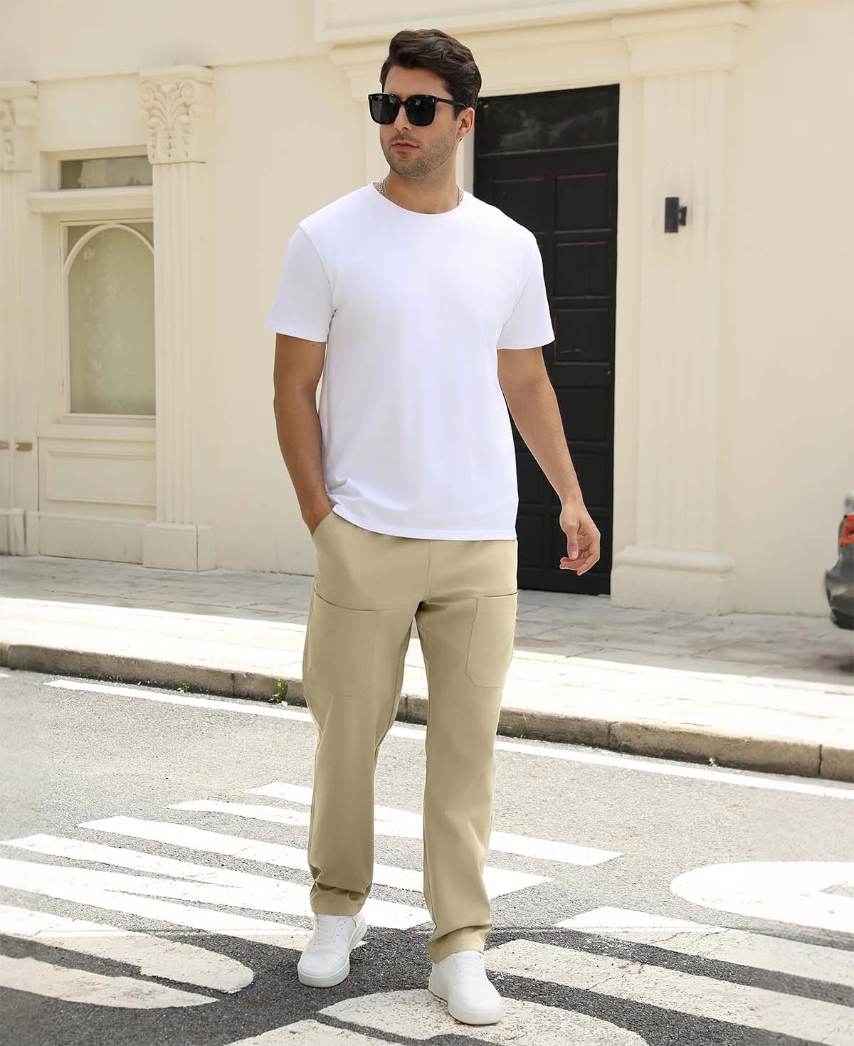 Man wearing white tee and khaki durable multipants standing on a street, hand in pocket, showcasing daily wear.