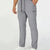 Man in light grey multipants with drawstring waist and multiple pockets, white sneakers, hand in pocket showing side logo.