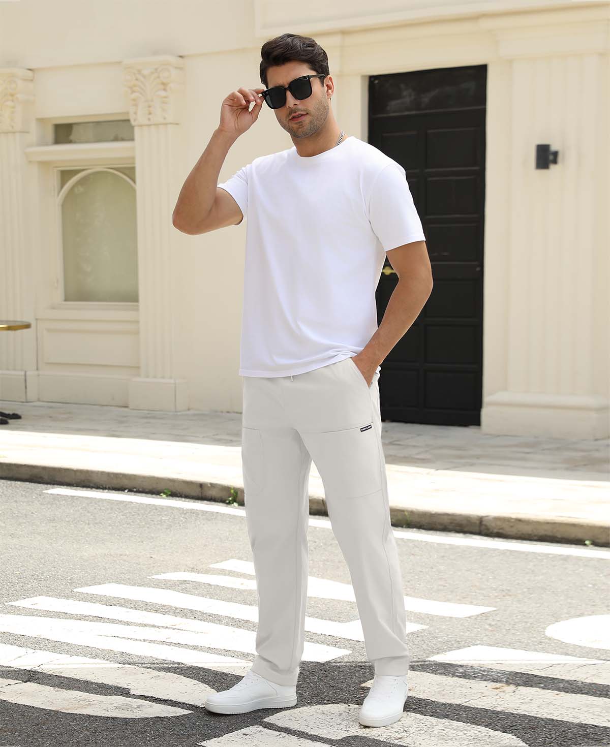Man adjusting sunglasses, revealing side pocket details of white multipants, highlighting fit and pocket layout.