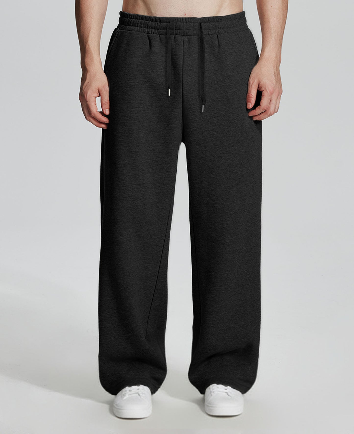 Model in black Men's Fleece Sweatpants ¨C Wide Leg Heavyweight Lounge Pants with white sneakers, showing drape and relaxed fit.
